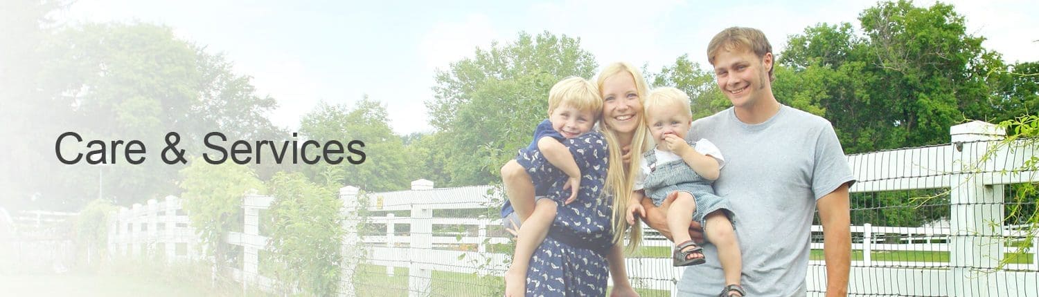 Young family standing beside fence