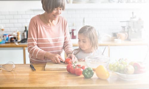 Grandmother teaching granddaughter to cook