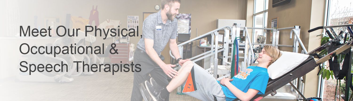 Physical therapist assisting teenage boy with leg exercises