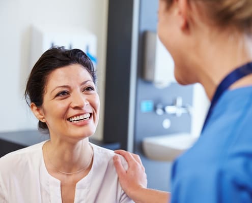 A healthcare provider in scrubs interacting with a patient