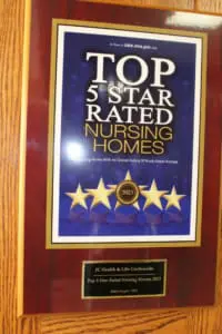 Plaque on wood surface displaying a 'Top 5 Star Rated Nursing Homes' award with five stars and a gold seal.