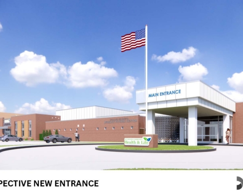 Rendering of a prospective health center entrance with a tall American flag, curved driveway, and a 'Health & Life' sign near the roundabout.