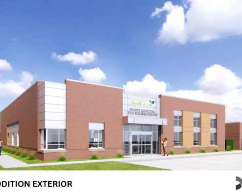 Exterior view of a modern brick medical building with a glass entrance and parking lot, under a blue sky.